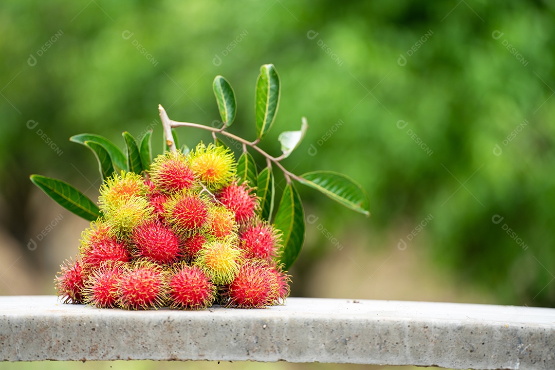 A pilha de frutas deliciosas de Rambutan com folha verde.