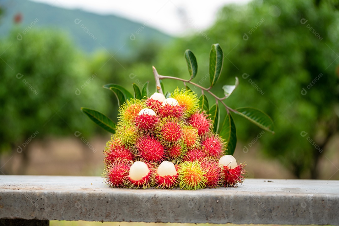 A pilha de frutas deliciosas de Rambutan com folha verde.