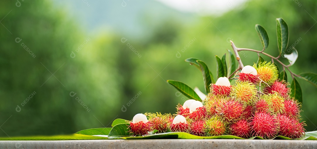 A pilha de frutas deliciosas de Rambutan com folha verde.