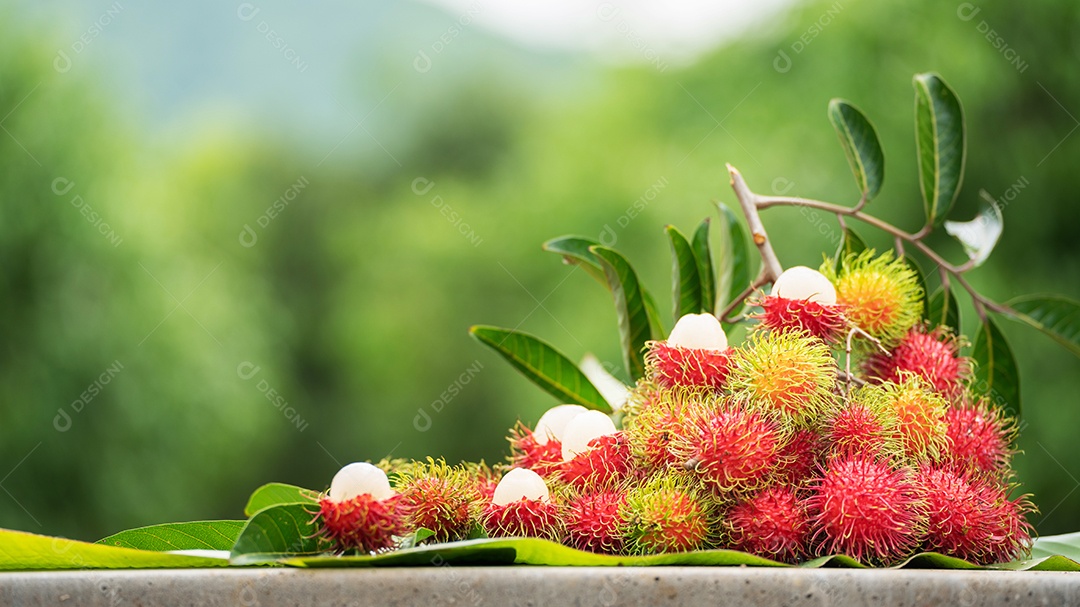 A pilha de frutas deliciosas de Rambutan com folha verde.