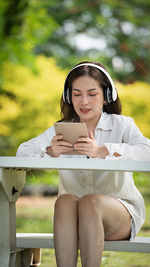 Menina linda jovem de camisa bege posando na cidade verde.