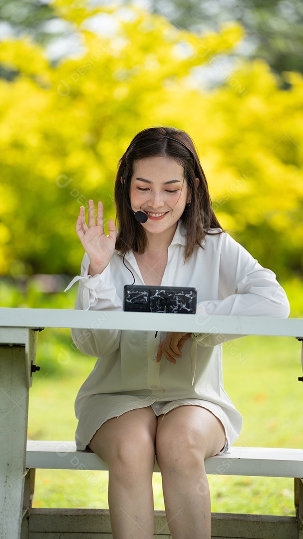 Mulher de sorriso pensativo no parque usando telefone inteligente.