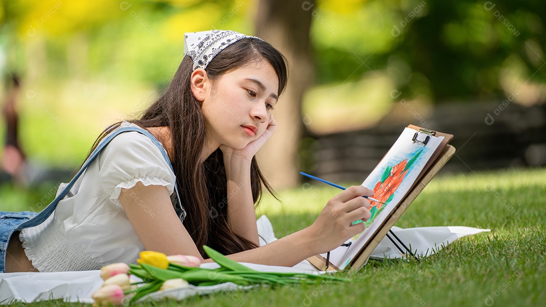 Encantadora mulher sentada na manta no parque no verão ensolarado.