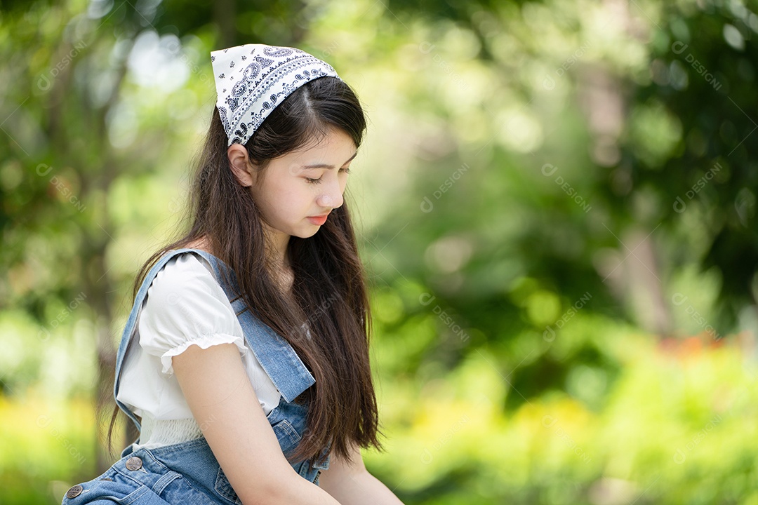 Retrato de foto sorrindo menina no parque verde da cidade.