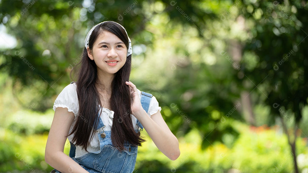 Retrato de foto sorrindo menina no parque verde da cidade.