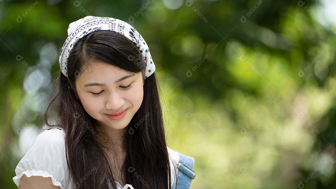Retrato de foto sorrindo menina no parque verde da cidade.