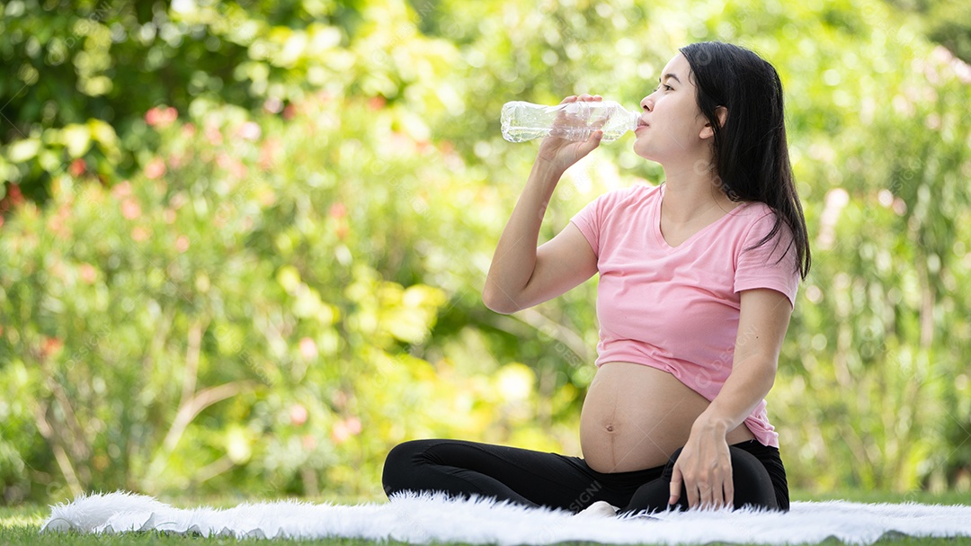 Mulher grávida bebendo água no Parque da Cidade, Grávida Relaxando e exercitando.