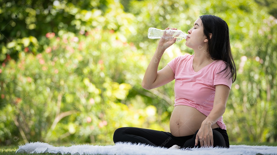 Mulher grávida bebendo água no Parque da Cidade, Grávida Relaxando e exercitando.