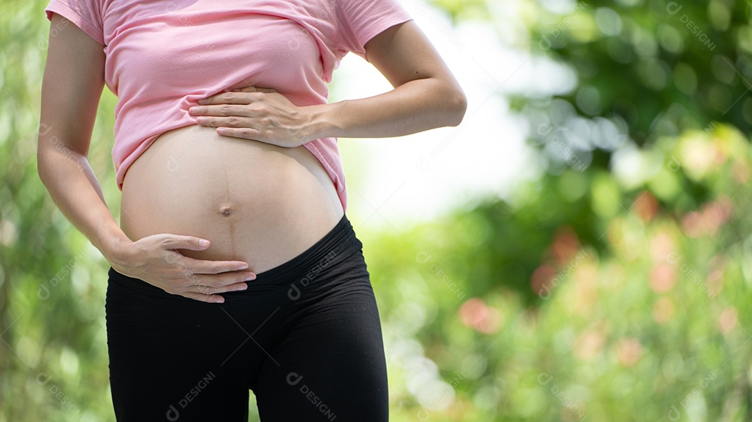 Mulher grávida tocando a barriga no Parque da Cidade, Grávida Relaxando e exercitando.