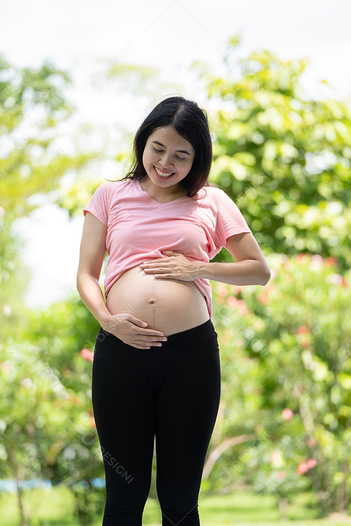 Mulher grávida tocando a barriga no Parque da Cidade, Grávida Relaxando e exercitando.
