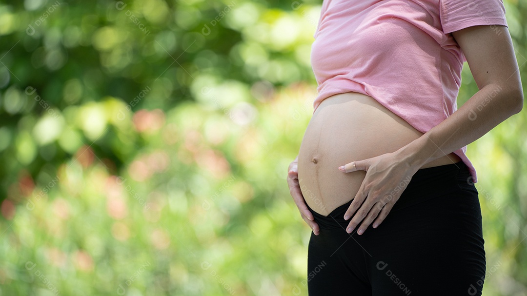 Mulher grávida tocando a barriga no Parque da Cidade, Grávida Relaxando e exercitando.