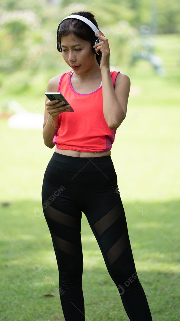 Menina linda jovem de camisa bege posando na cidade verde.