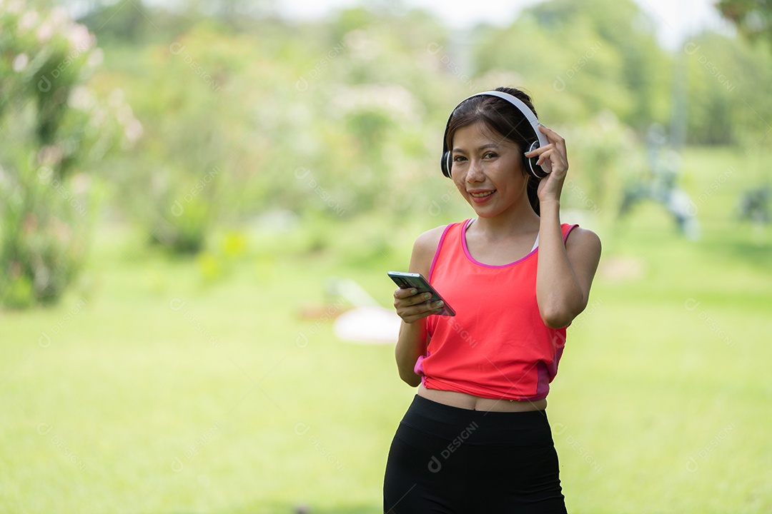 Menina linda jovem de camisa bege posando na cidade verde.