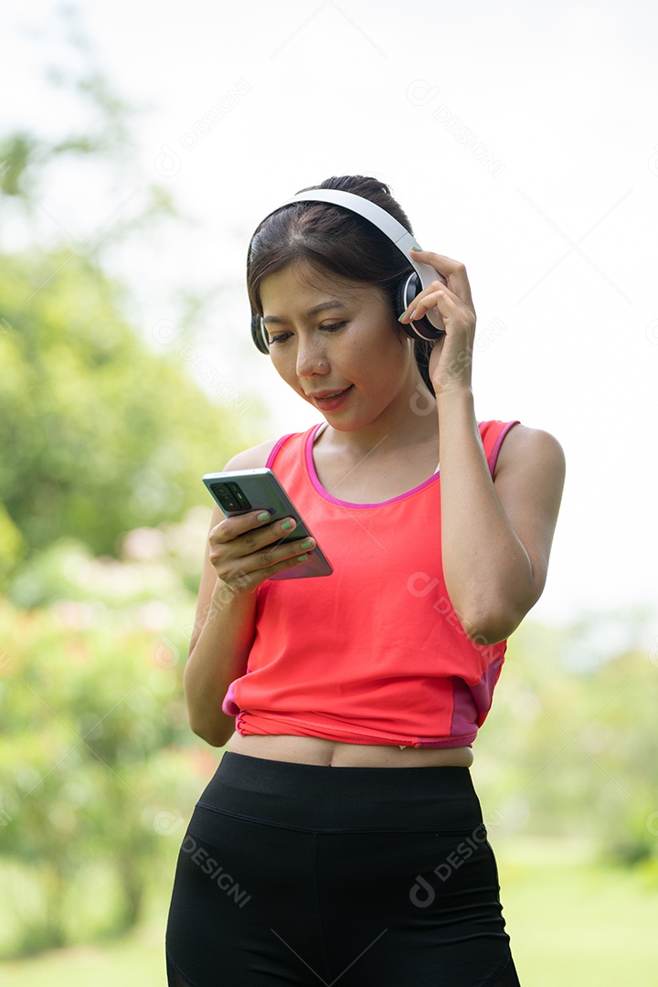 Menina linda jovem de camisa bege posando na cidade verde.