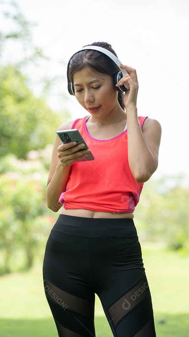 Menina linda jovem de camisa bege posando na cidade verde.