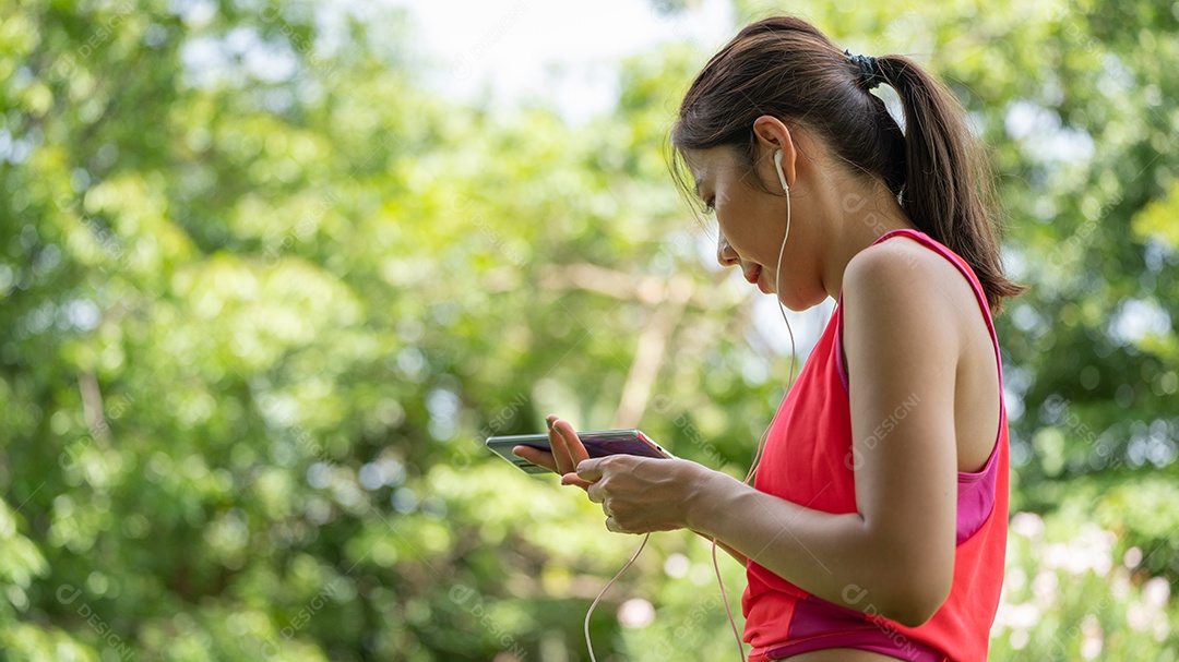 Menina linda jovem de camisa bege posando na cidade verde.
