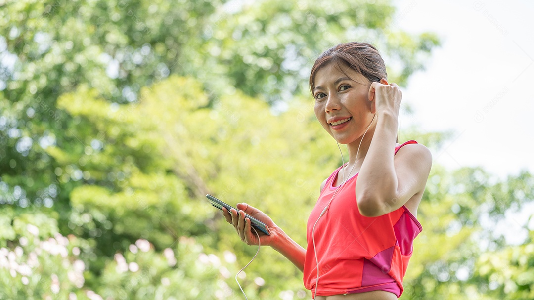 Young beautiful girl in beige shirt posing in the green city.