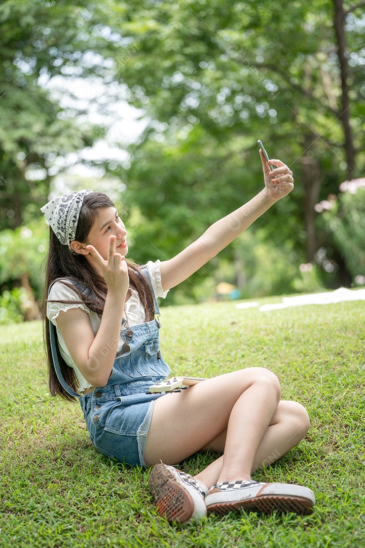 Retrato de menina tirando fotos fazendo gestos no parque verde da cidade verde em spri