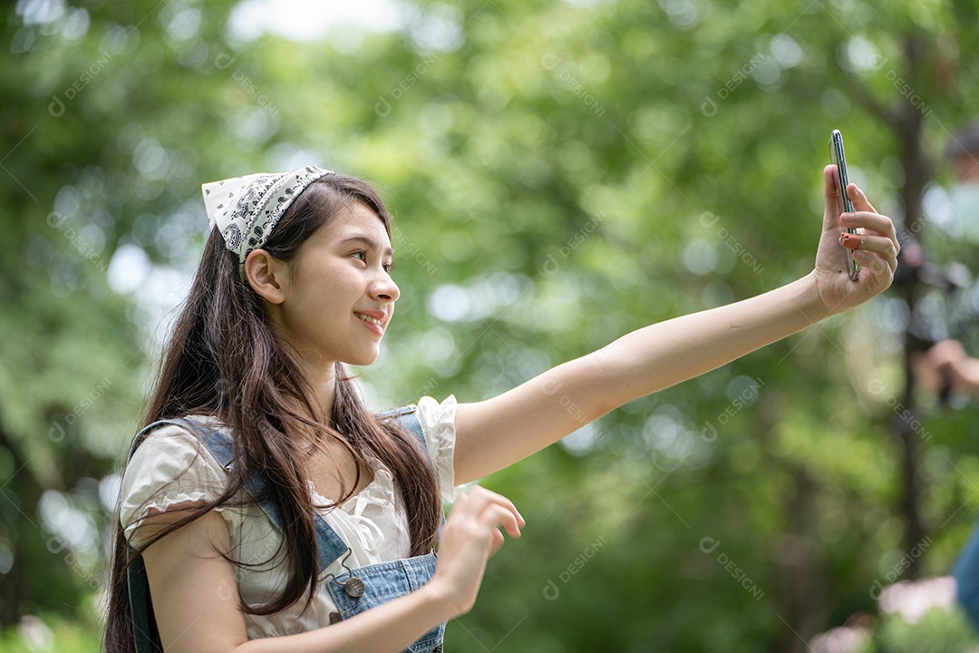 Retrato de menina tirando fotos fazendo gestos no parque verde da cidade verde em spri
