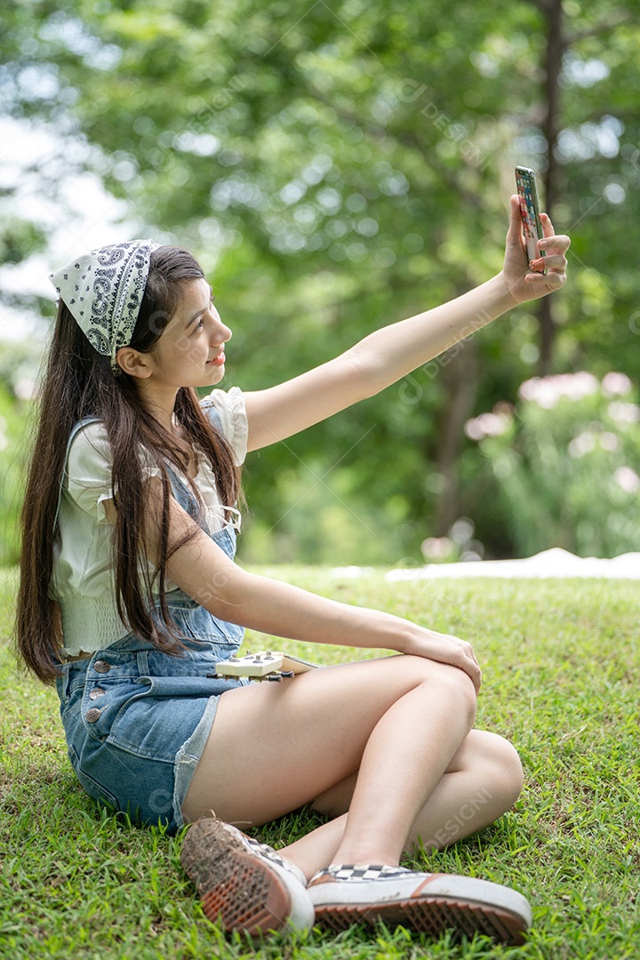 Retrato de menina tirando fotos fazendo gestos no parque verde da cidade verde em spri