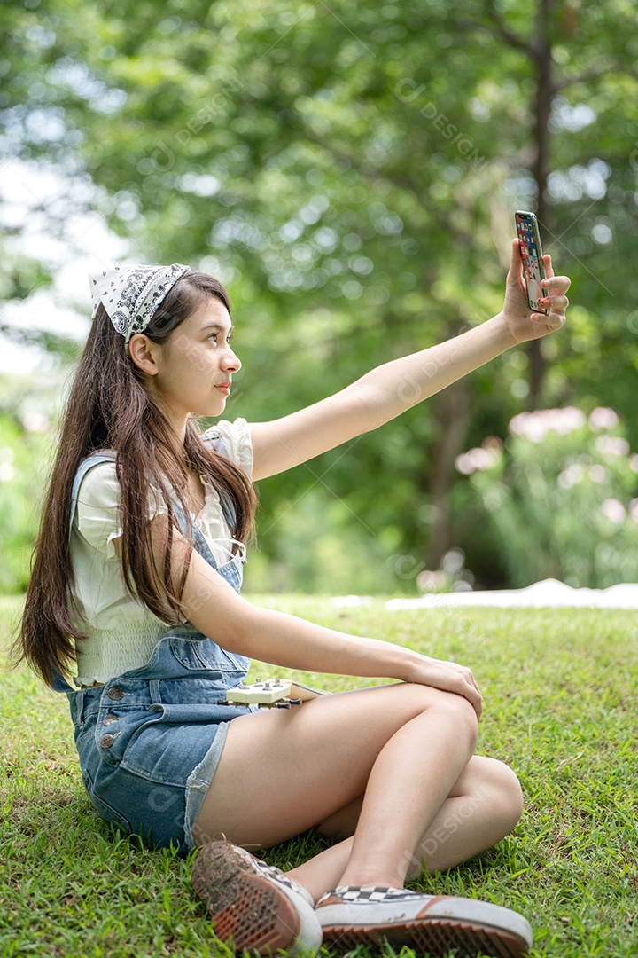 Retrato de menina tirando fotos fazendo gestos no parque verde da cidade verde em spri