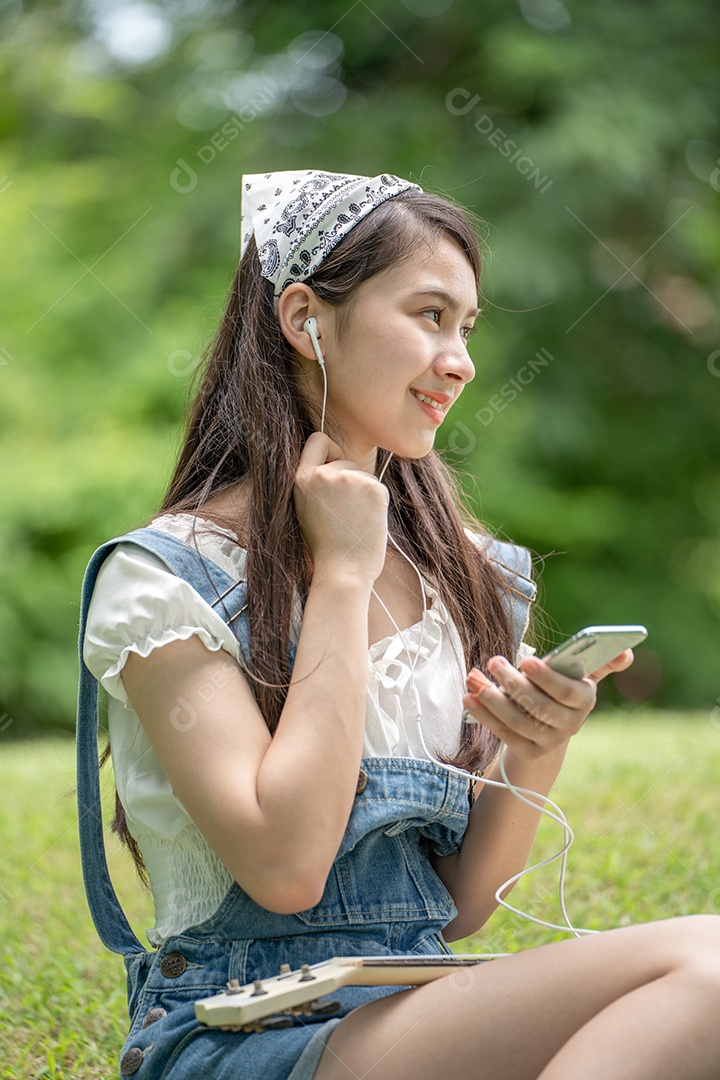 Retrato de menina com fones de ouvido fazendo gestos no parque verde da cidade verde em spri