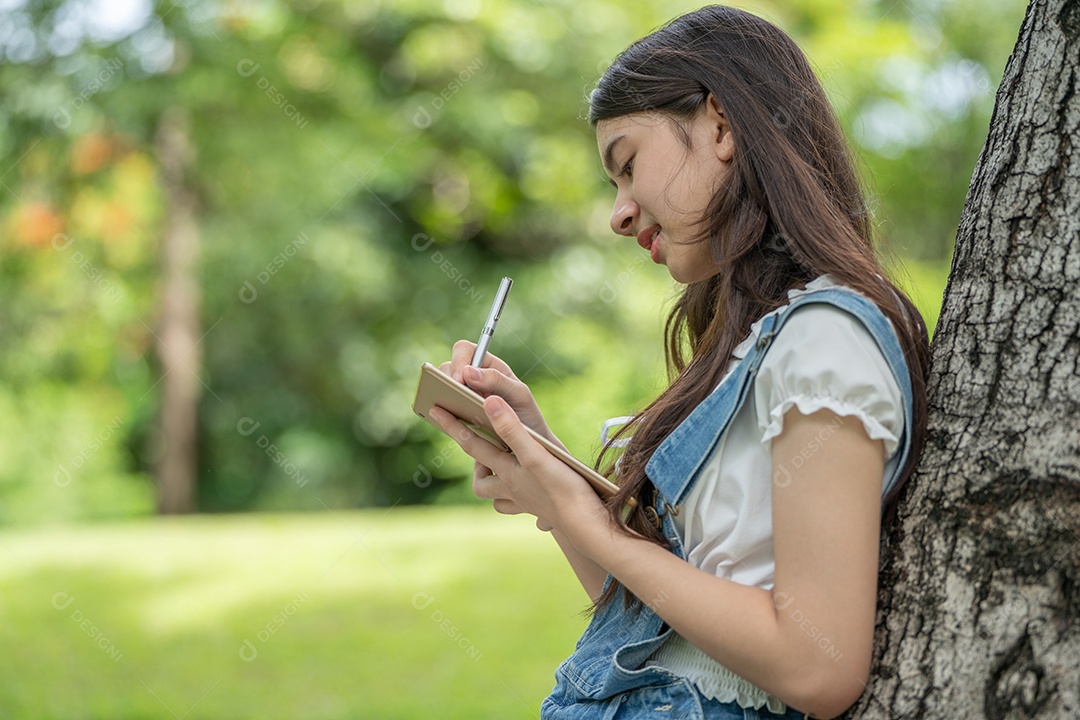 Retrato de menina segurando tablet fazendo gestos no parque verde da cidade verde em spri