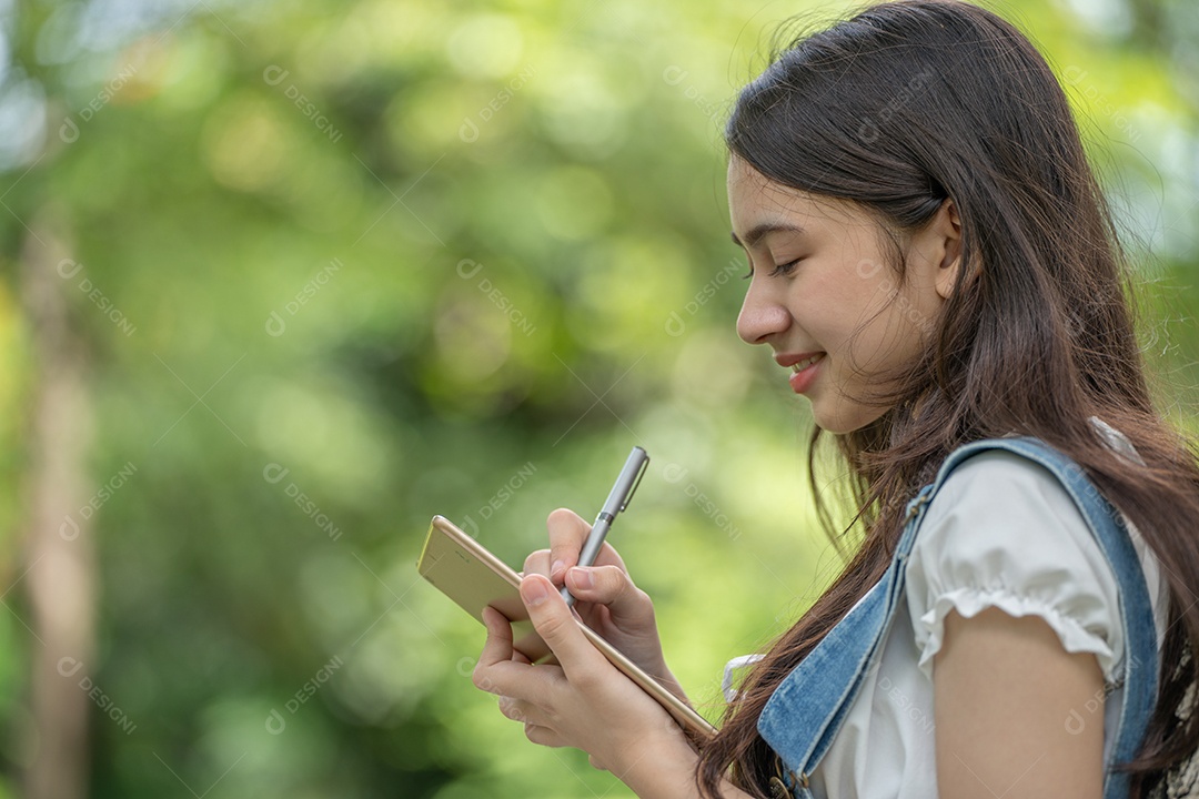 Retrato de menina segurando tablet fazendo gestos no parque verde da cidade verde em spri