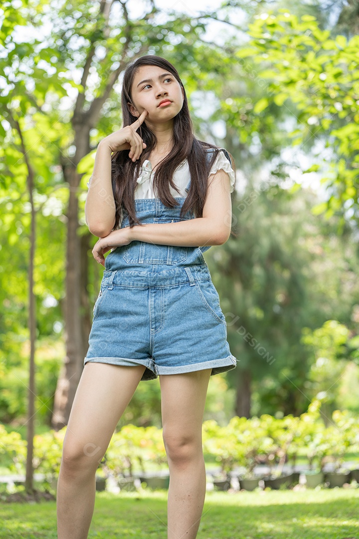 Retrato de menina fazendo gestos no parque verde da cidade verde em spri