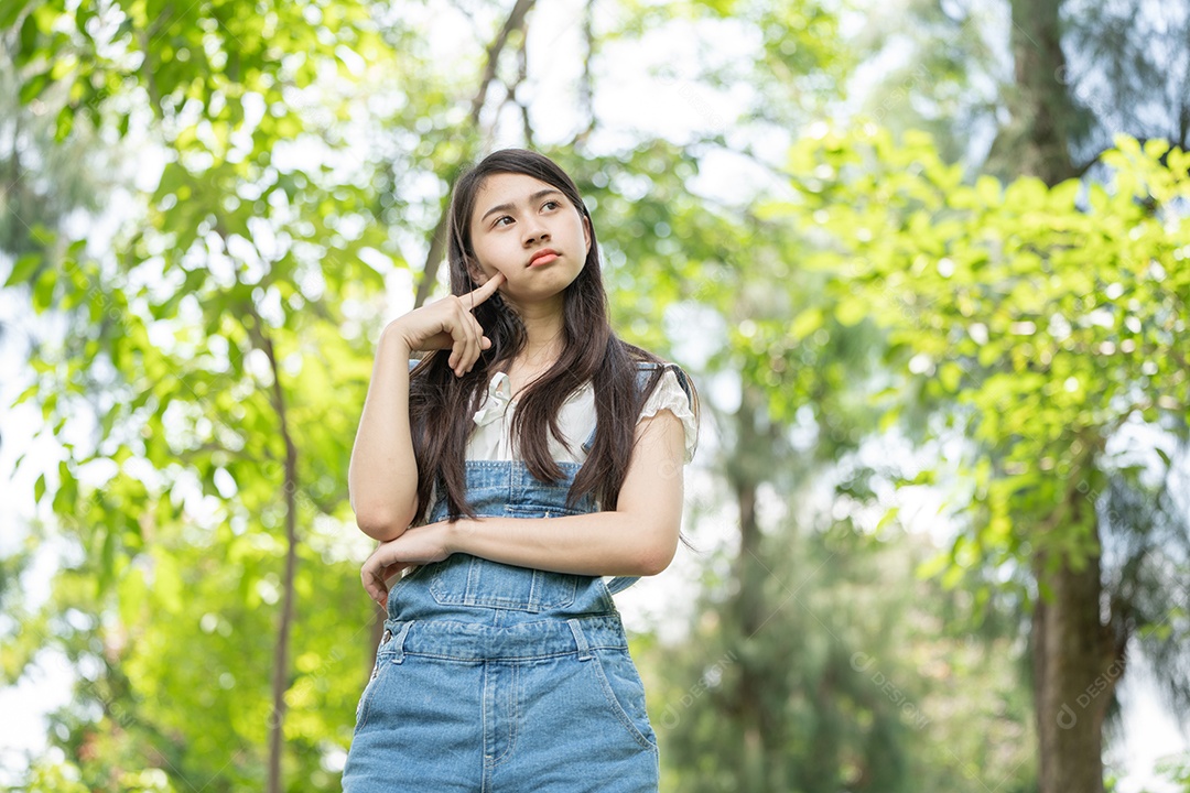 Retrato de menina fazendo gestos no parque verde da cidade verde em spri