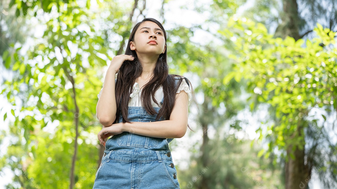 Retrato de menina fazendo gestos no parque verde da cidade verde em spri