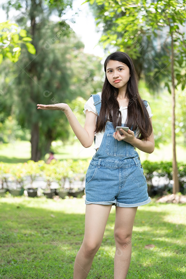 Retrato de menina fazendo gestos no parque verde da cidade verde em spri