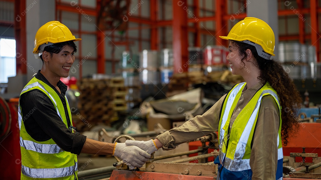 Capataz e mulher em traje de segurança apertam as mãos e concluem um trabalho