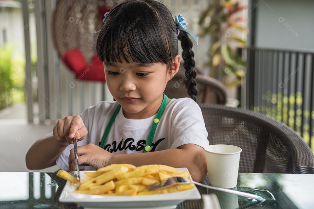 Jovem garota asiática comendo batatas fritas diversão feliz batata fast food.