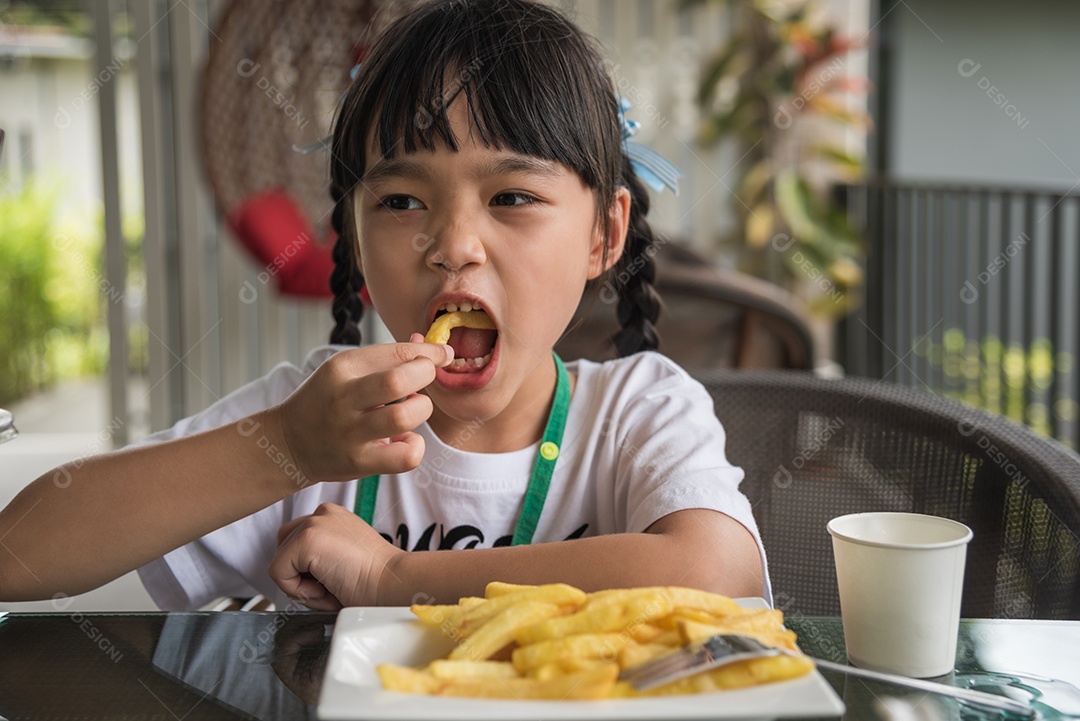Jovem garota asiática comendo batatas fritas diversão feliz batata fast food.