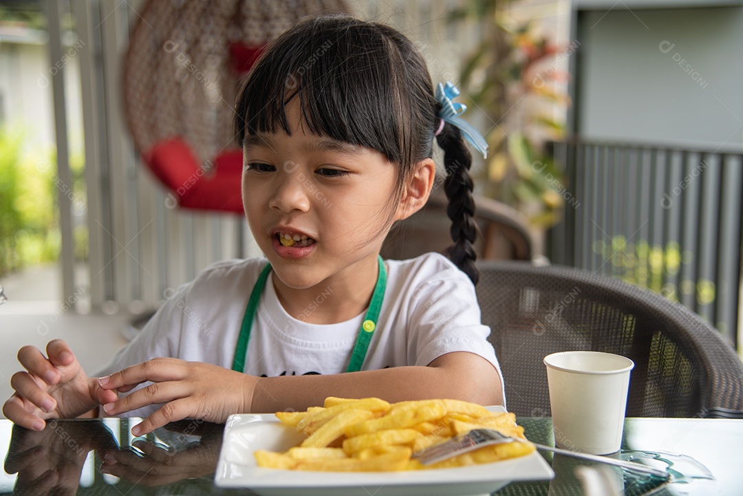 Jovem garota asiática comendo batatas fritas diversão feliz batata fast food.