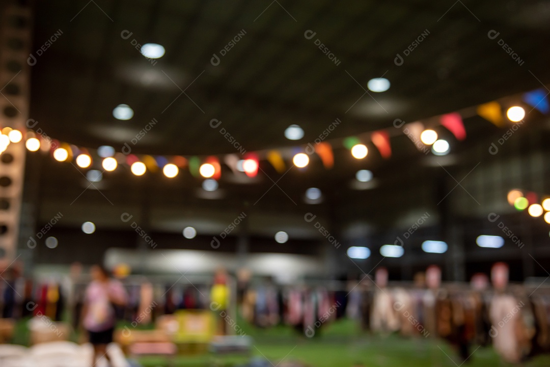 Imagem borrada de pessoas do festival do mercado noturno andando na estrada com luz bokeh para segundo plano.