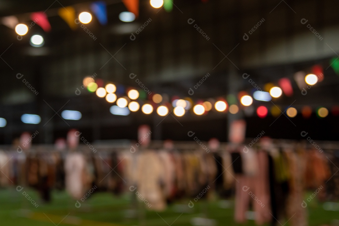 Imagem borrada de pessoas do festival do mercado noturno andando na estrada com luz bokeh para segundo plano.