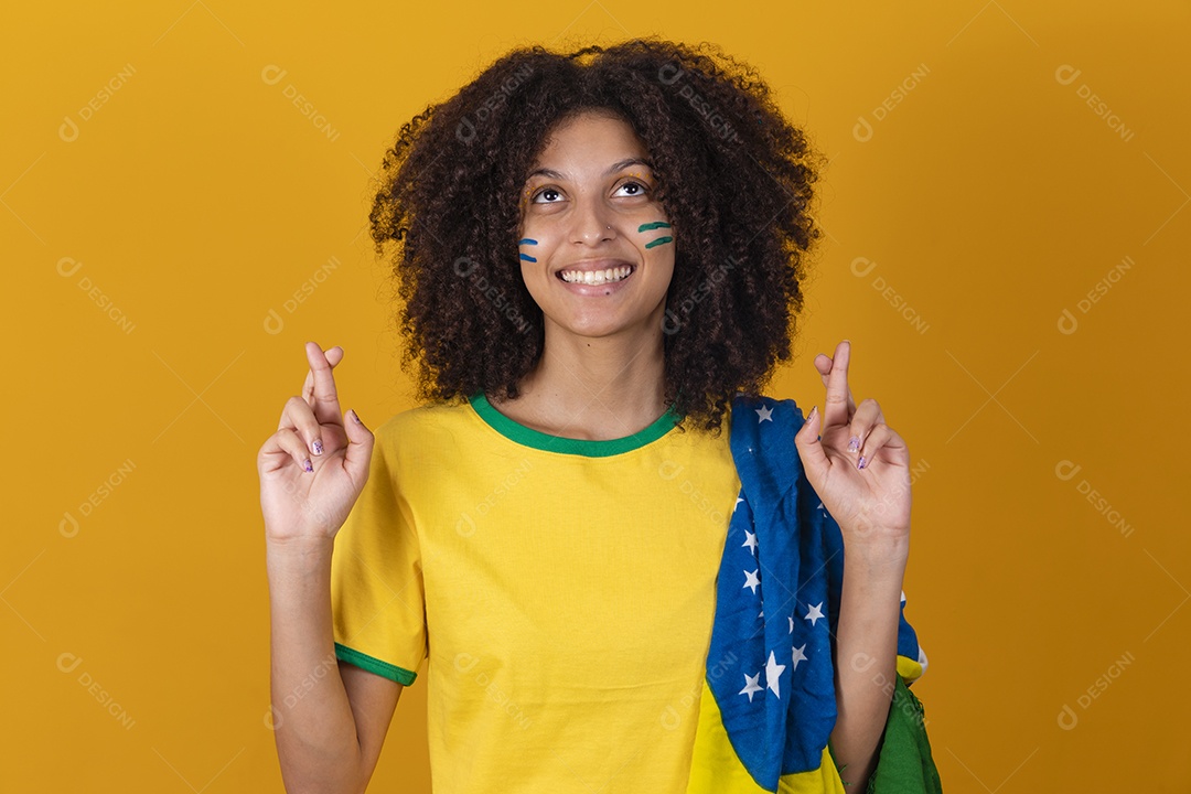 Mulher afro-brasileira vestindo camiseta do Brasil fazendo gestos