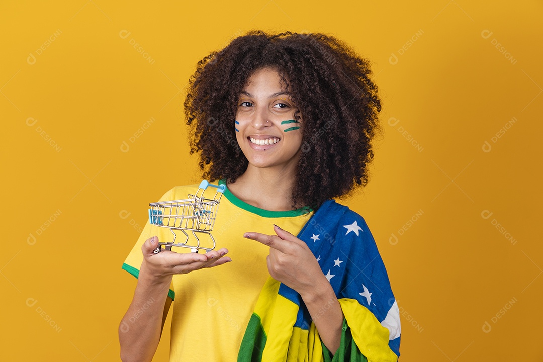 Mulher afro-brasileira vestindo camiseta do Brasil e segurando um carrinho de compras