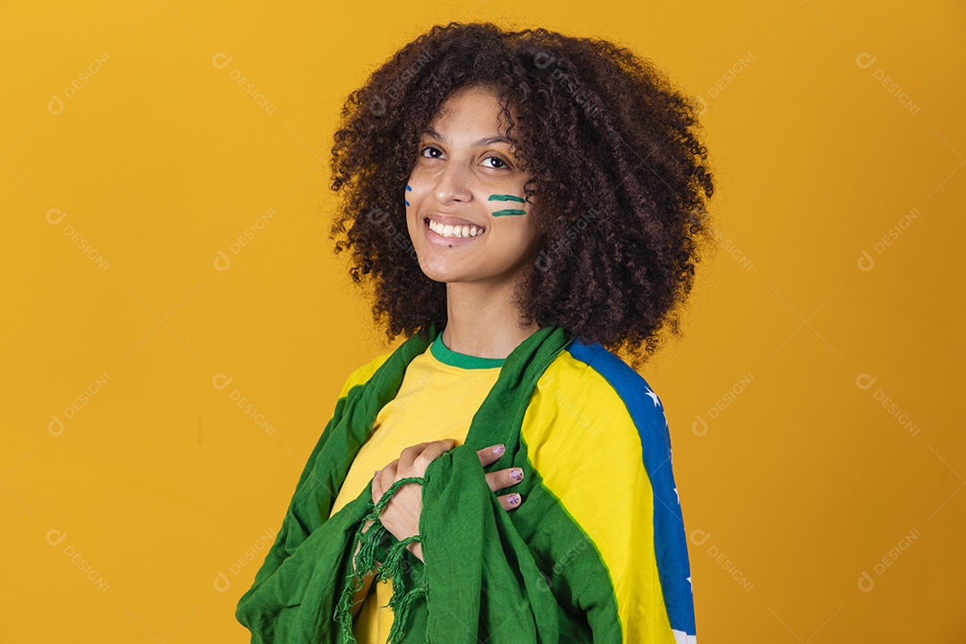 Mulher afro-brasileira vestindo camiseta do Brasil e bandeira nacional