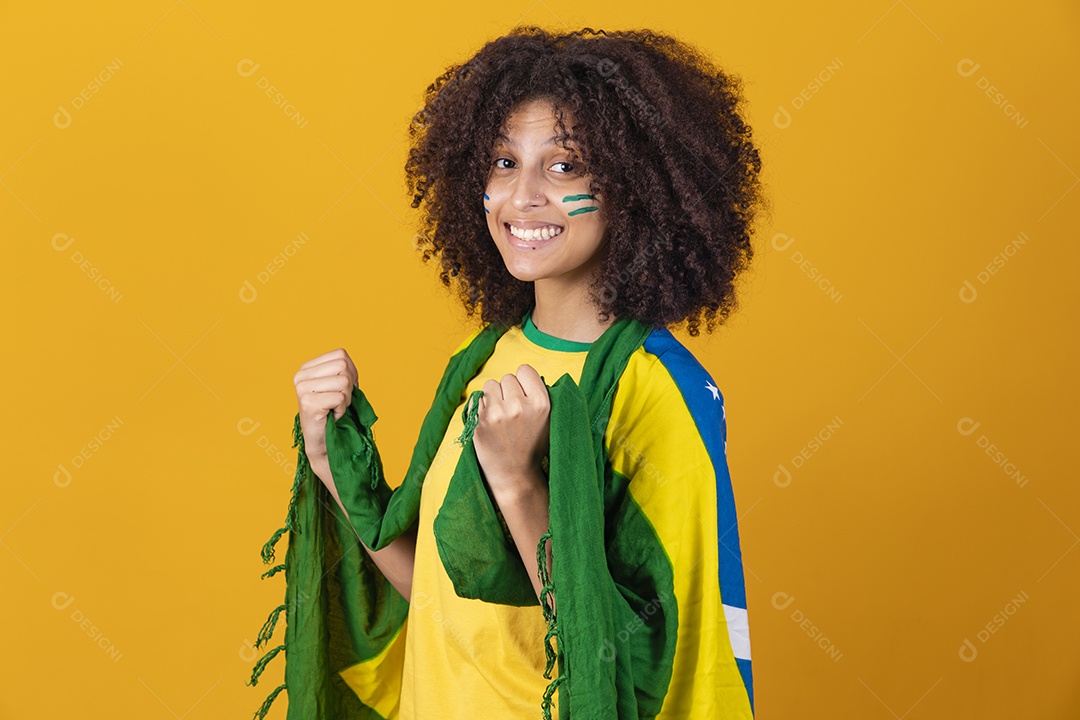 Mulher afro-brasileira vestindo camiseta do Brasil e bandeira nacional