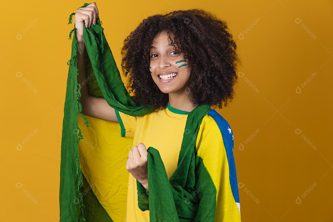 Mulher afro-brasileira vestindo camiseta do Brasil e bandeira nacional