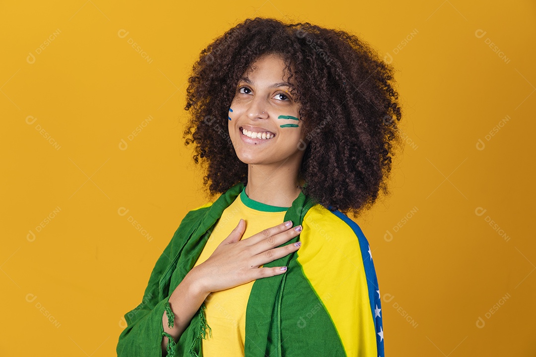 Mulher afro-brasileira vestindo camiseta do Brasil e bandeira nacional