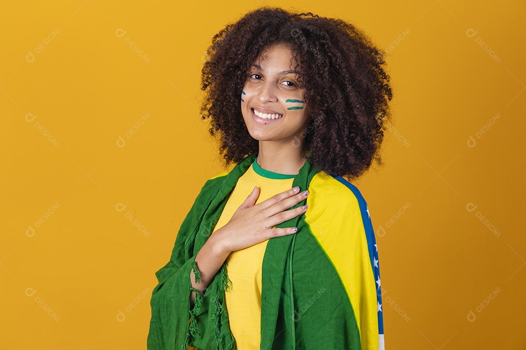 Mulher afro-brasileira vestindo camiseta do Brasil e bandeira nacional