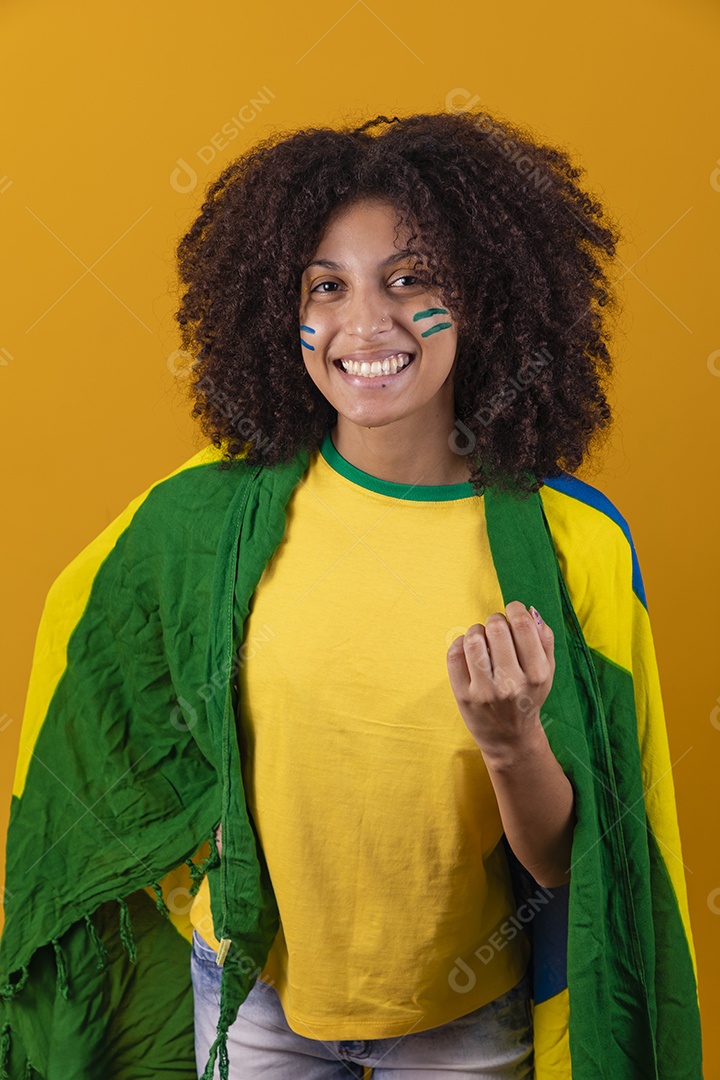 Mulher afro-brasileira vestindo camiseta do Brasil e bandeira nacional