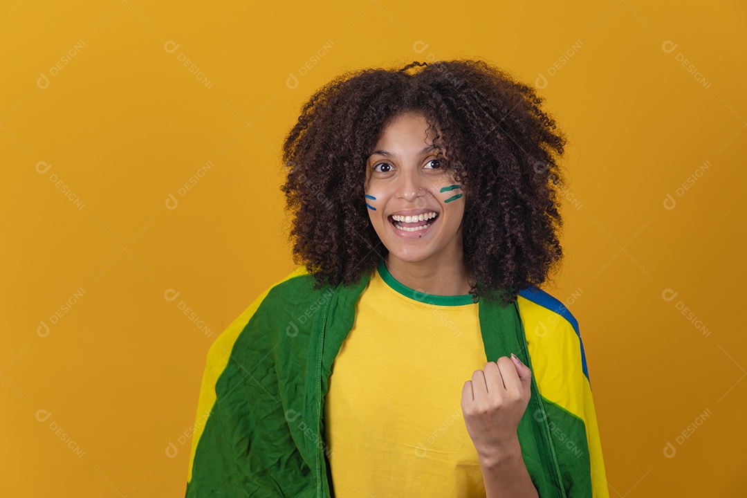 Mulher afro-brasileira vestindo camiseta do Brasil e bandeira nacional