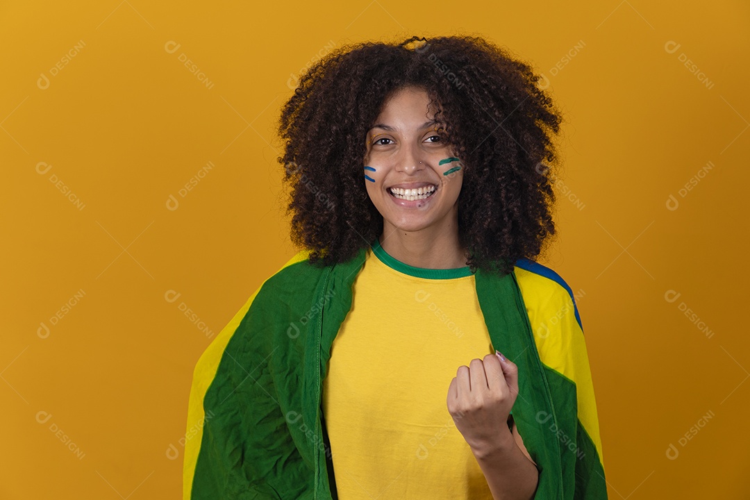 Mulher afro-brasileira vestindo camiseta do Brasil e bandeira nacional