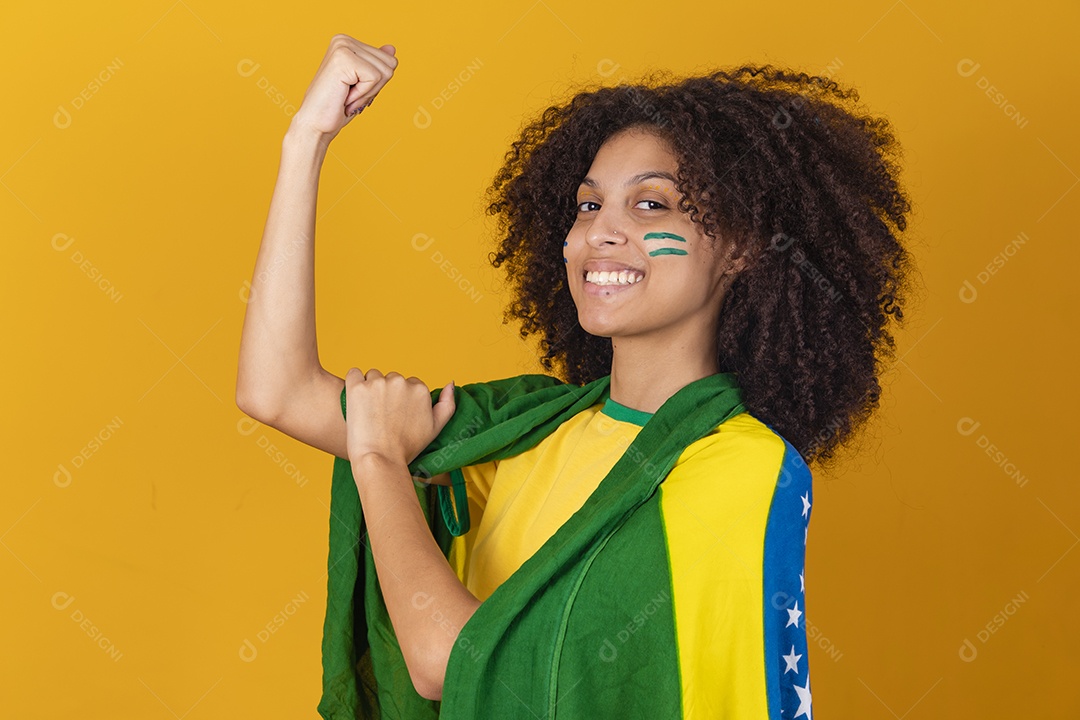 Mulher afro-brasileira vestindo camiseta do Brasil e bandeira nacional
