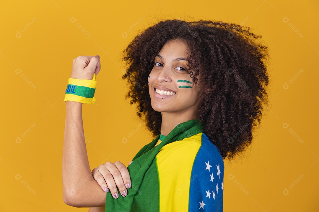 Mulher afro-brasileira vestindo camiseta do Brasil e bandeira nacional